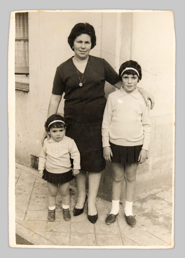 Ceferina García García with her daughters in front of the house she and her husband built together. 
Vega-Gijón, 1962 © Cristina Fernández-Moser 