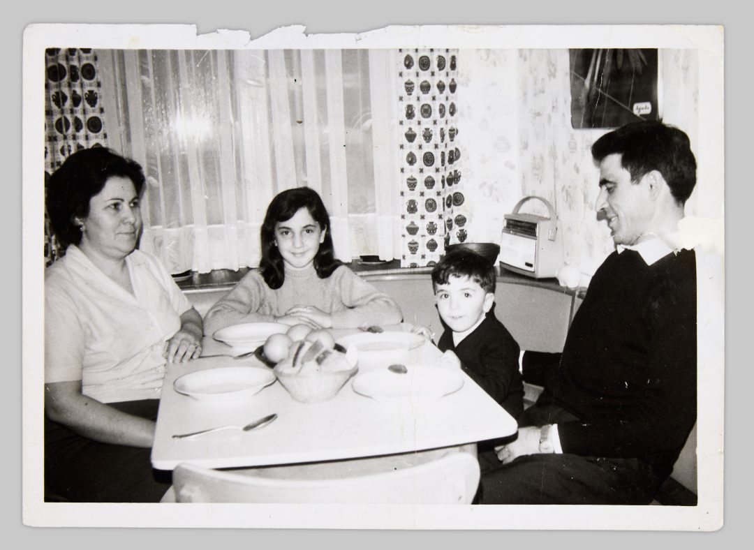 Ceferina García García and Ovidio Fernández García with their daughter Cristina and their son Ovidio Jr. Westfalenstraße 273, Essen-Steele, c. 1970. In the corner, the “Concert Boy” radio by Grundig can be seen. This allowed the family to listen to the daily Spanish-language news broadcasts on WDR 4 and keep up to date with events in Germany. At the same time, the device allowed them to receive radio programs from Spain. © Cristina Fernández-Moser